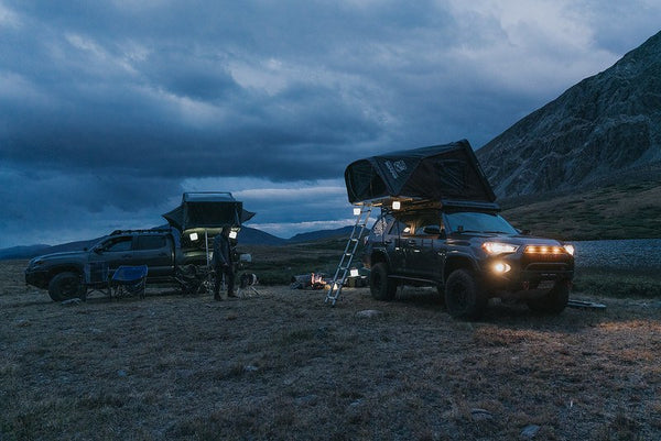 Person and two cars at campsite