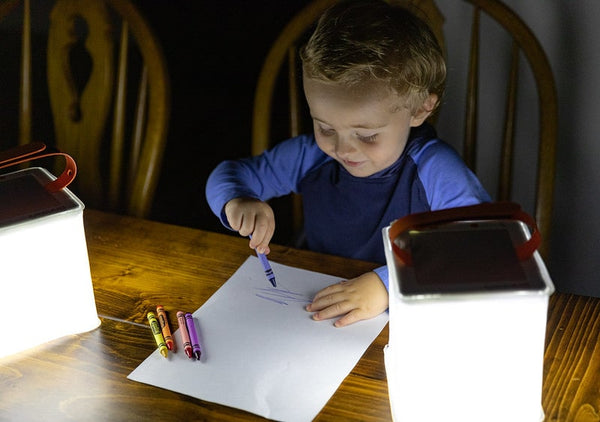 Small child coloring at a table using LuminAID PackLite Nova  Source: Nick Zupanicich