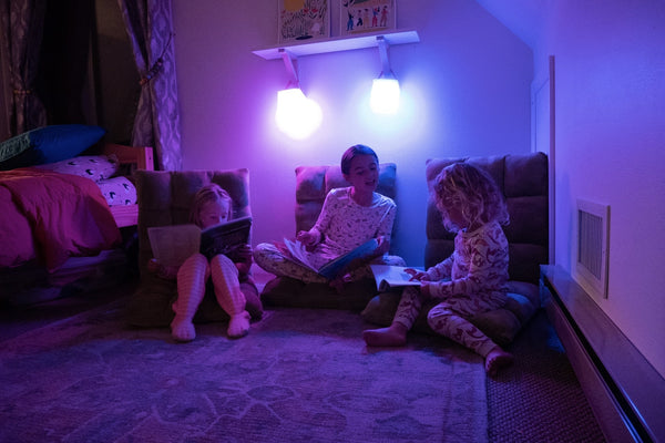 3 children reading together using 2 LuminAID PackLite Spectra lanterns  Source: Kati Whelan