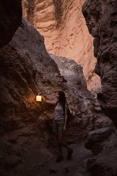 Woman holding LuminAID Lantern between the rocks of Death Valley Source: Ura Druchuck