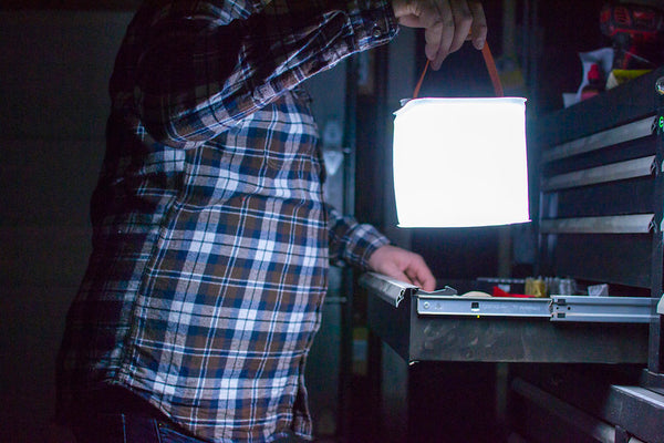 Man looking for tools in the dark with his LuminAID lantern. Source: Molly McFaddin