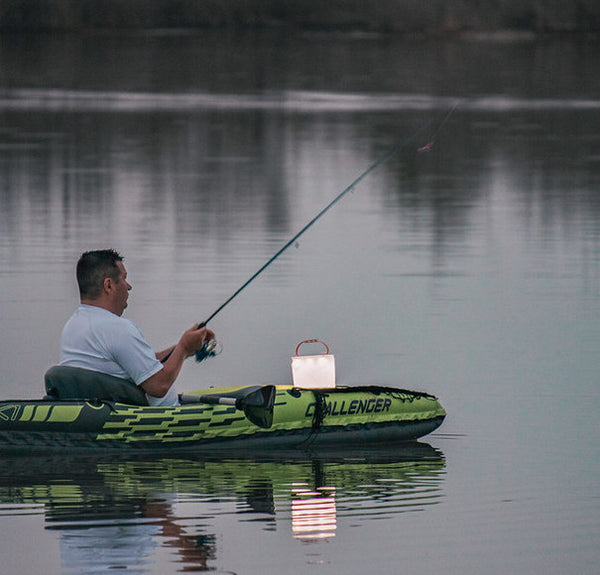 Man fishing in a canoe with his LuminAID