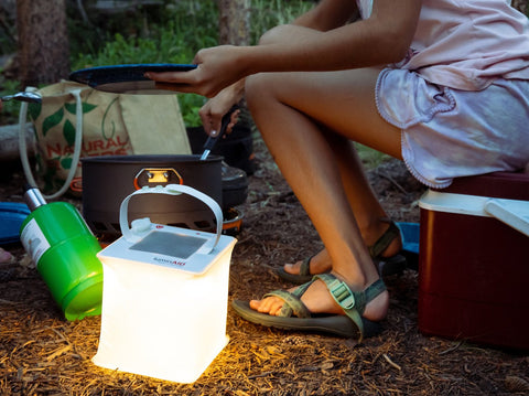 Firefly lantern lights up campsite cooking.