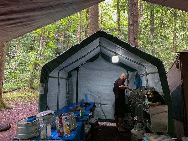 Man making food in the wild with great kitchen set up