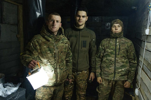 Three young men in Ukraine with a LuminAID lantern - credit Sasha Leahovcenco / Mosaic