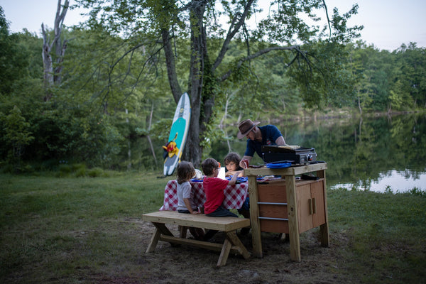 Family sitting at a picnic table with LuminAID lantern. Source: Kaily Gashi (@kailygashi), Harriman State Park, NY