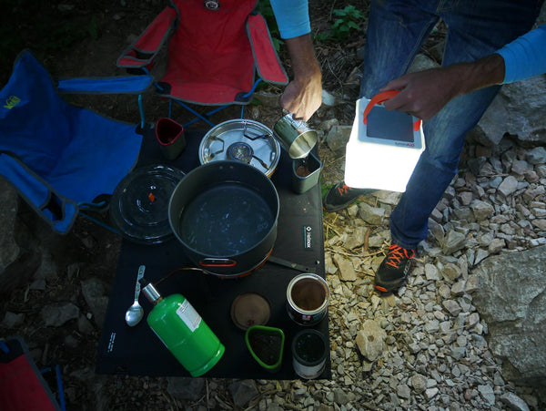 Camper preparing a drink using LuminAID as a light source. Source: Kati Whelan