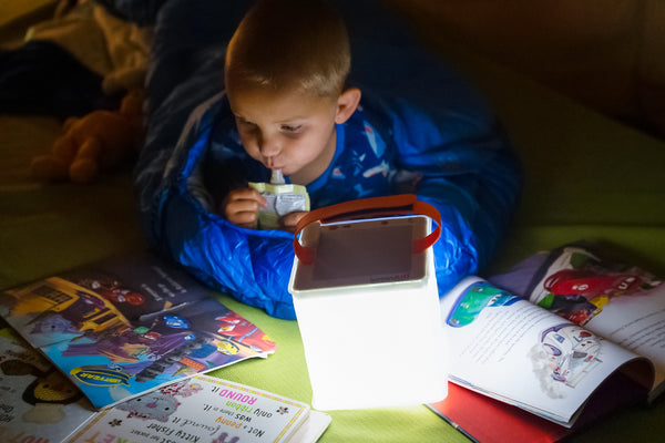 Child reading with LuminAID lantern during a power outage. Source: Haley Haws