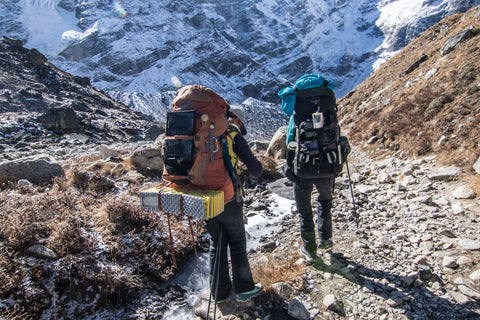 Two people backpacking with lanterns.