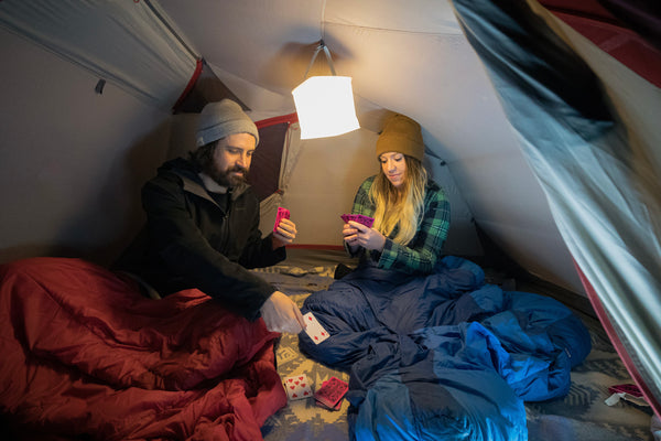 2 people playing a card game in their sleeping bags. Source: Nick Zupancich