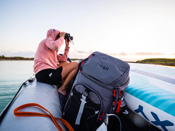 Man in a boat on water with his Arctic Zone cooler 