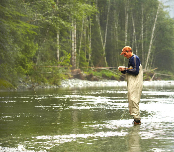 Man fishing out in a river with protective fishing gear. Source: Thinkstock