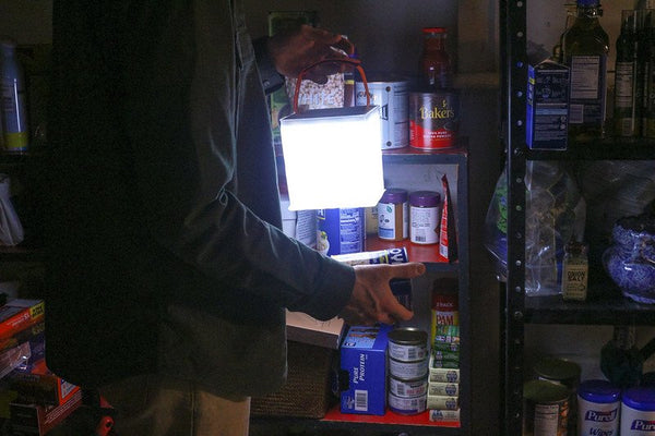 Person holds LuminAID lantern and canned food