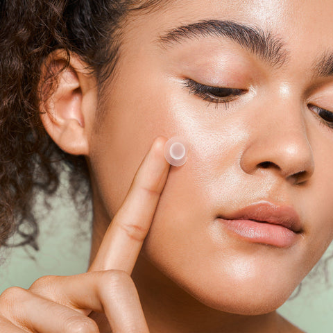 Girl holding pimple patch over her skin 