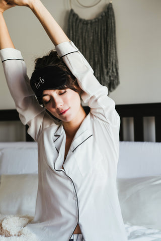 Girl in 'brb' silk sleeping eye mask stretching after waking up