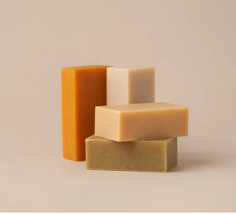 Stack of shampoo and conditioner bars with a tan background