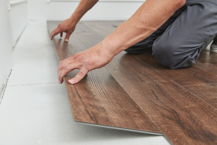 worker joining vinyl floor planks