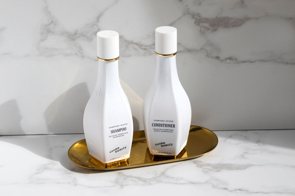 Cuvee Shampoo and Conditioner Product Images on a Gold Plate