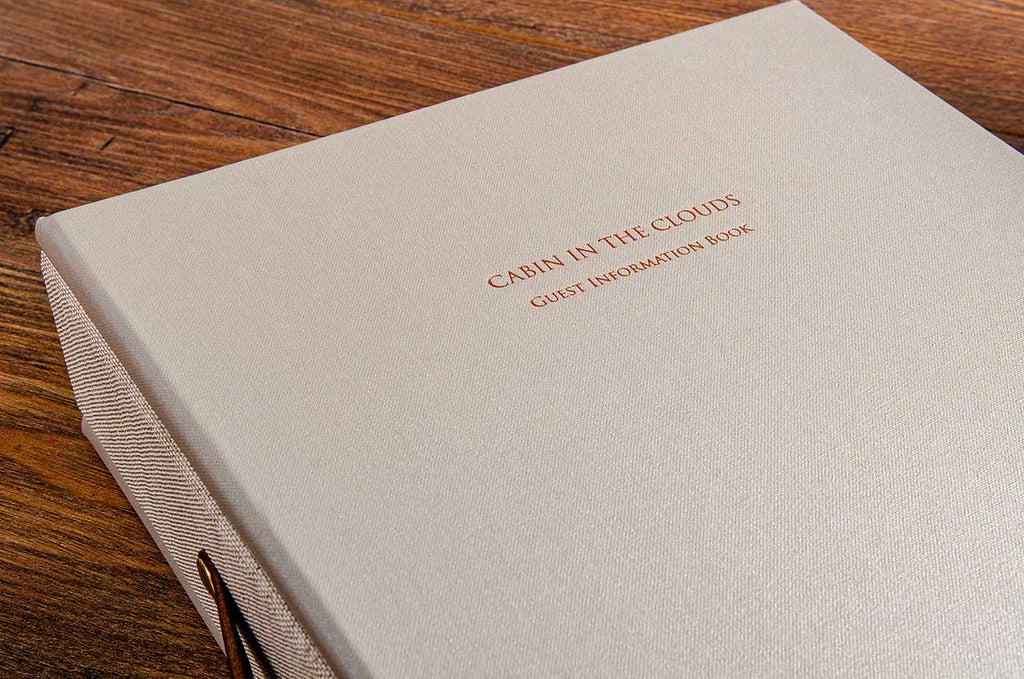 Gold foil embossing on the cover a custom made guest information file covered in beige buckram for boutique guest house