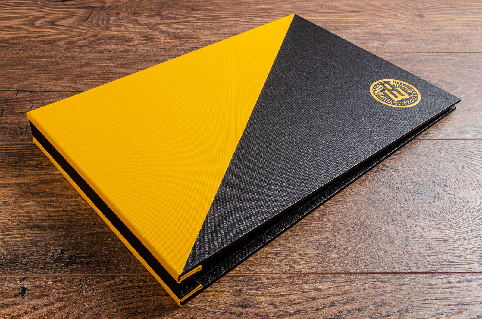 Hidden screw post portfolio binder in black and yellow buckram with UV printed logo
