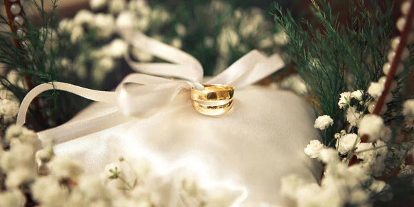 βέρες γάμου από κίτρινο χρυσό επάνω σε λευκό βελούδινο ύφασμα