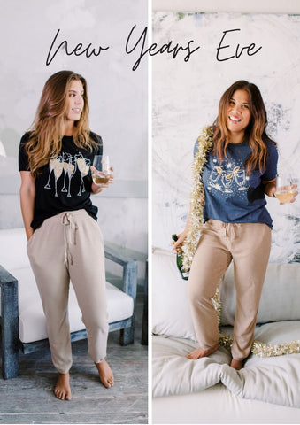 Two girls wearing new years even graphic t-shirts and joggers