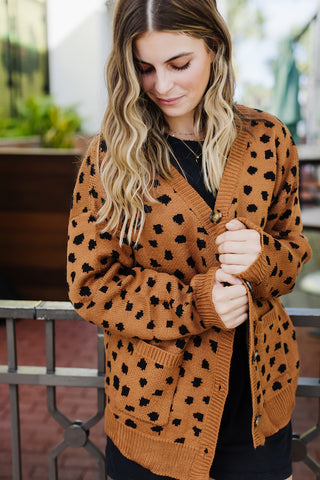 Girl wearing a rust and black leopard oversized cardigan