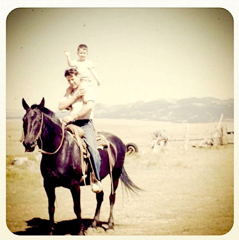 WoolTribe Yarn's Ladianne's father on her grandfather's shoulders on horseback on the sheep ranch in Montana.