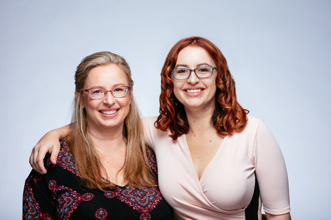 mom and adult daughter standing together smiling