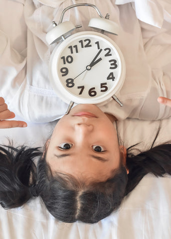 photo of little asian girl with clock.