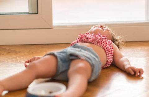toddler laying on the ground during a tantrum.