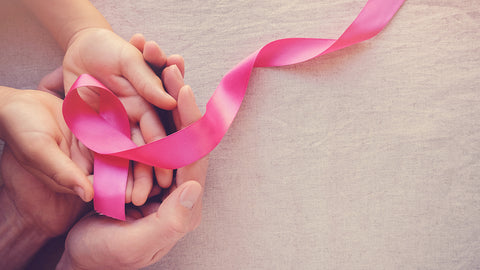 photo of hands holding pink cancer ribbon.