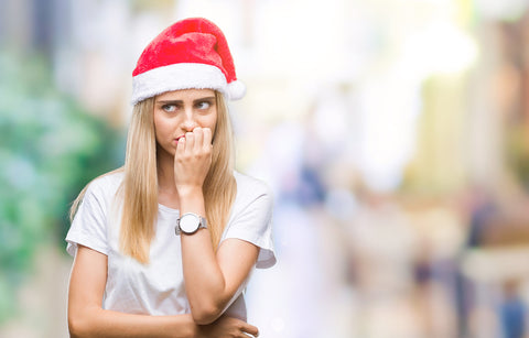 image of a woman wearing a santa hat and being stressed out.