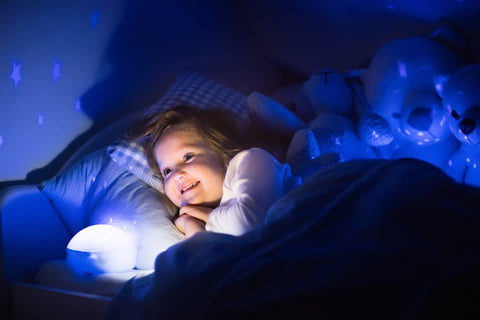 photo of a young girl looking at her night light happily before bed.