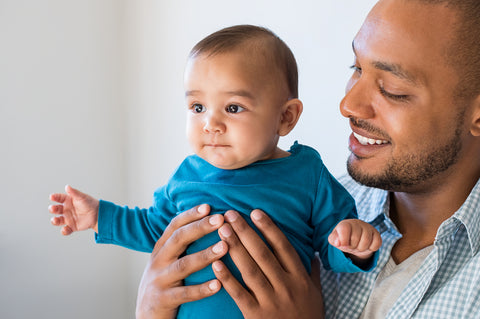 photo of a father holding his baby son. Close range shot.