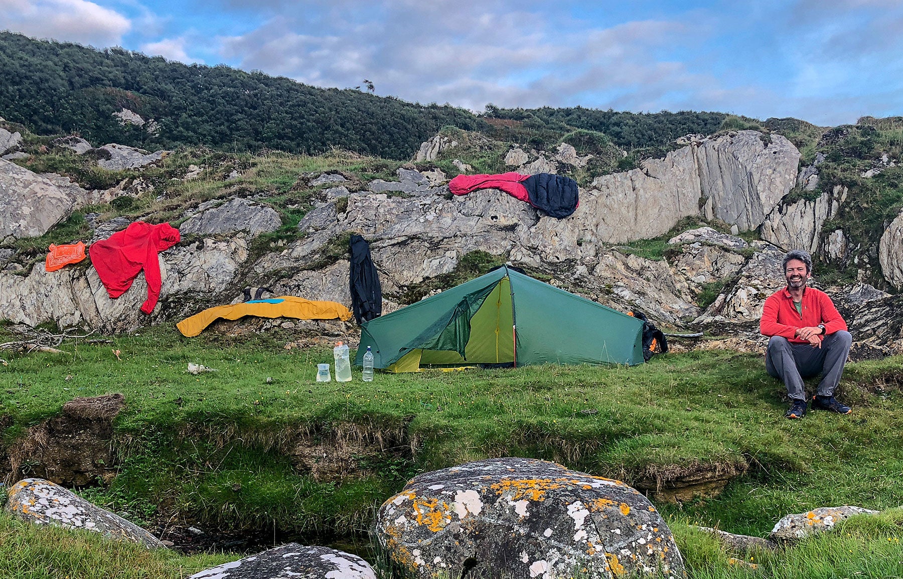 Photographer Quintin Lake beside his tent while wild camping