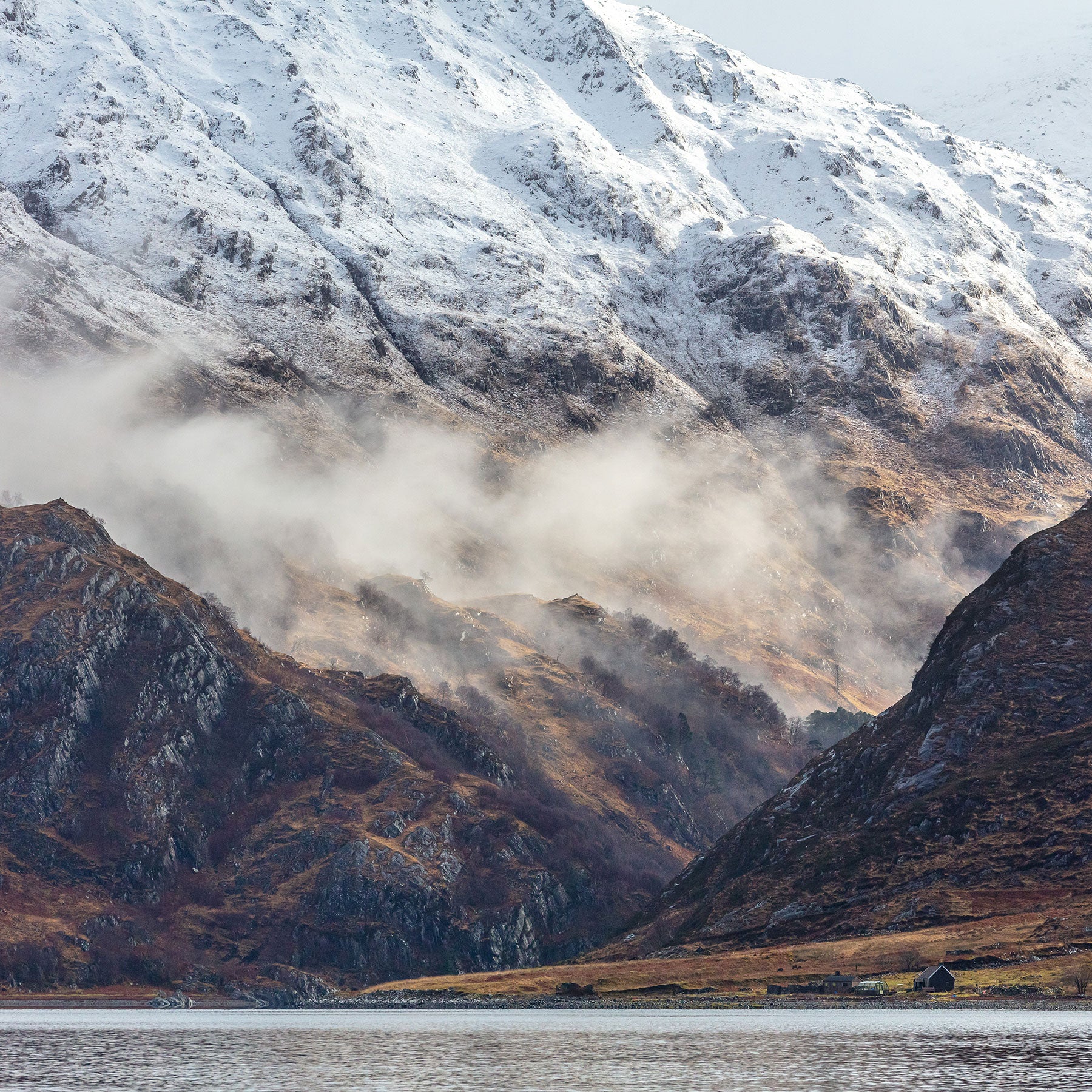 Majestic Scottish landscape with snow-clad mountains above a loch
