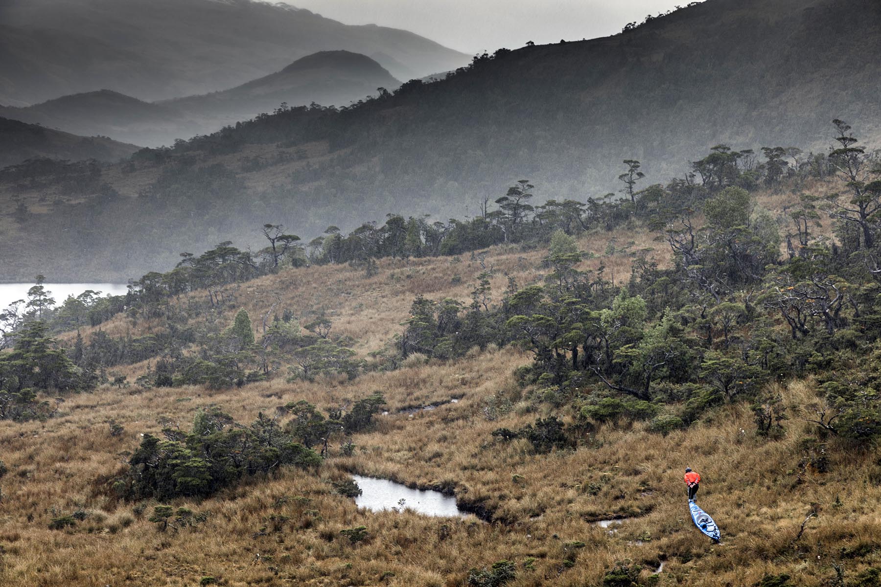 Portaging a kayak across rough overland terrain