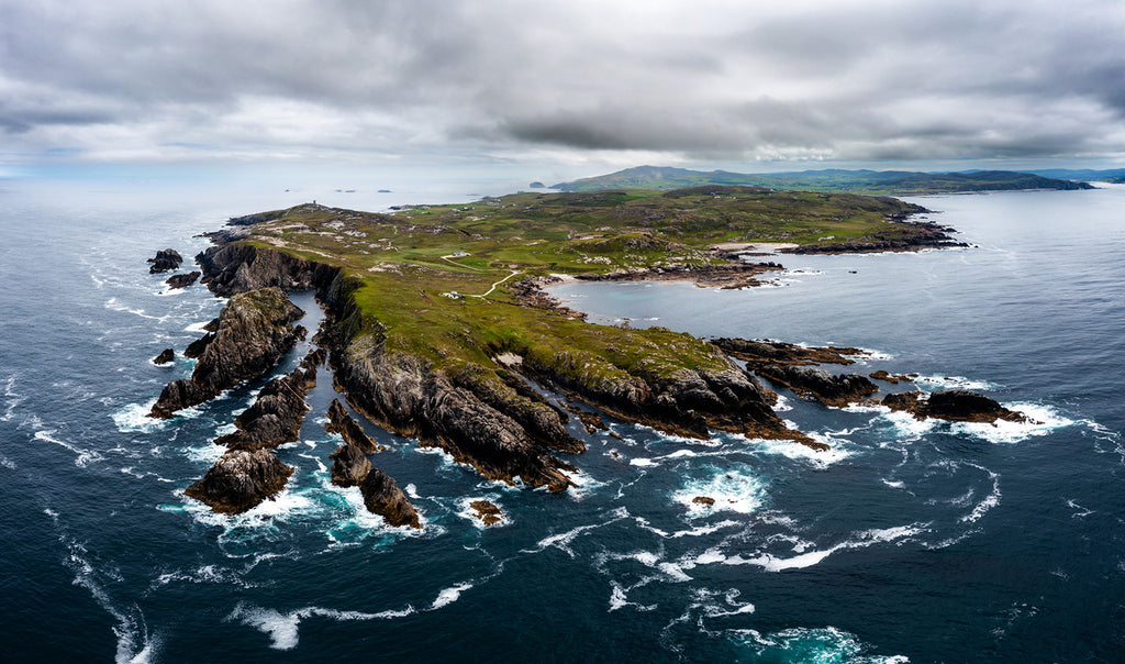 A stunning aerial view of the green and blue Malin Head coastline on an overcast and moody day in County Donegal, Ireland. 