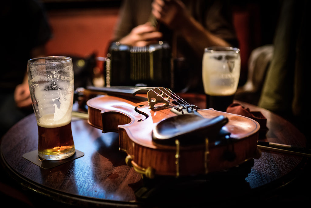 An Irish fiddle, a pint of Guinness and a pint of lager in a traditional Irish pub.