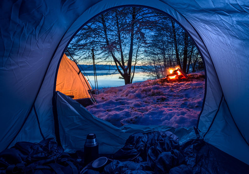 Winter camping scene with tents and a warm fire