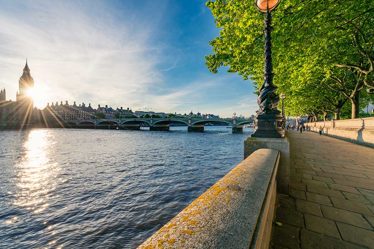 A sunny view of the River Thames and the Thames Path cycle route from the cycle path at Westminster Bridge near Big Ben and the Houses of Parliament.
