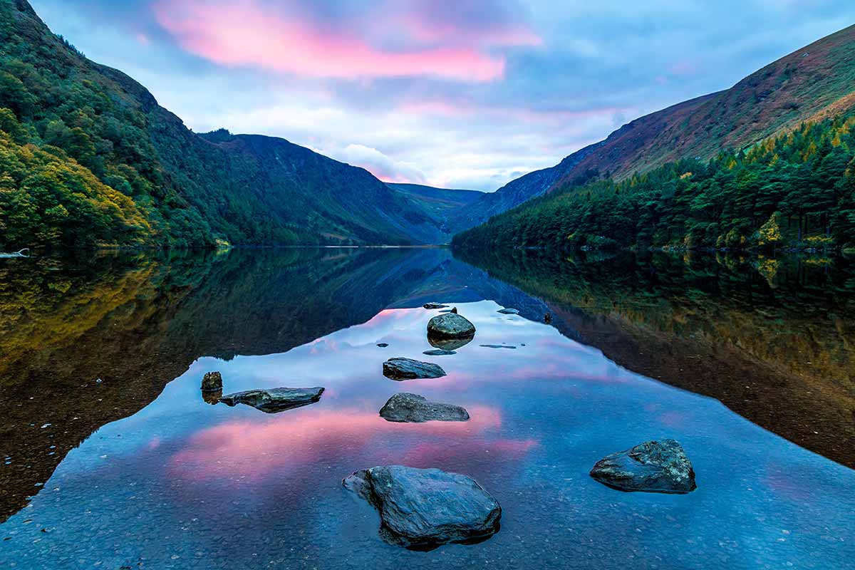 A pink sky and mountain view over Glendalough Lake, County Wicklow, Republic of Ireland. 