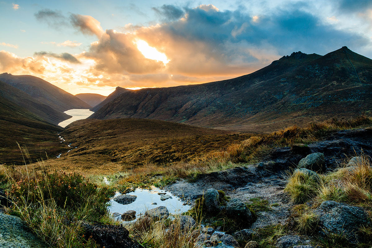 A view of a sunset and a river valley and mountains at Ben Crom Reservoir in the Mourne Mountains, Northern Ireland