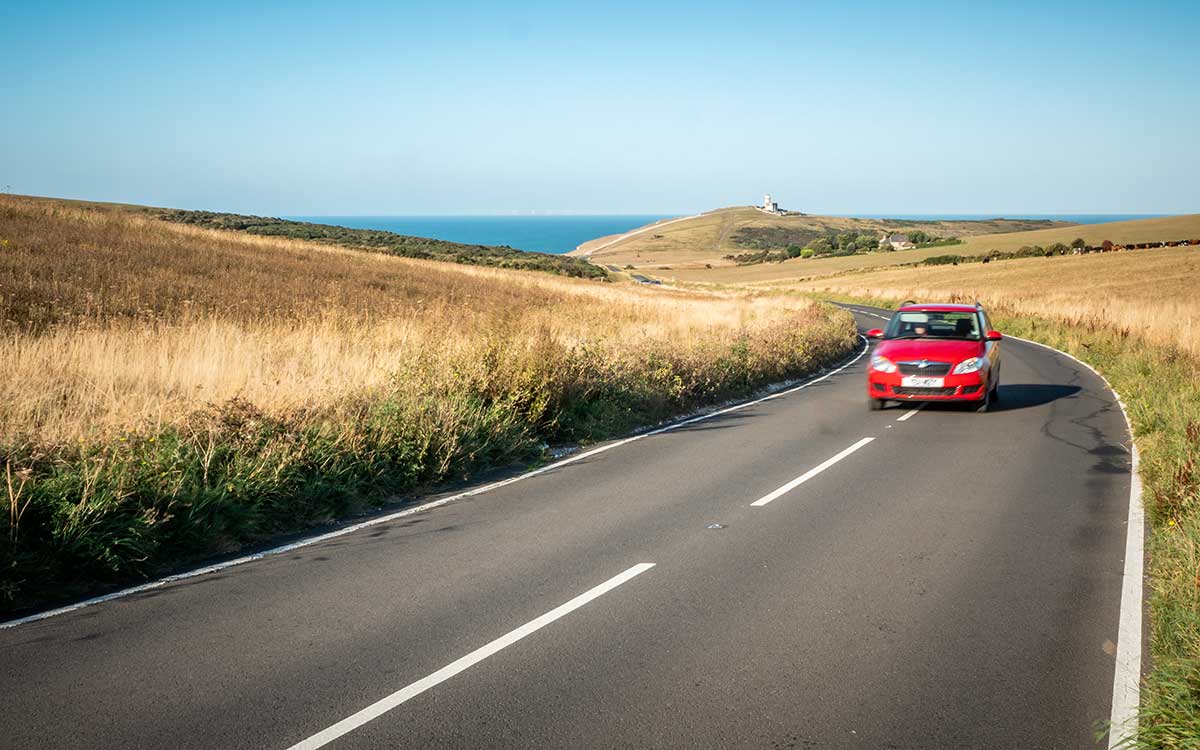 Red car taking a scenic route blue skies