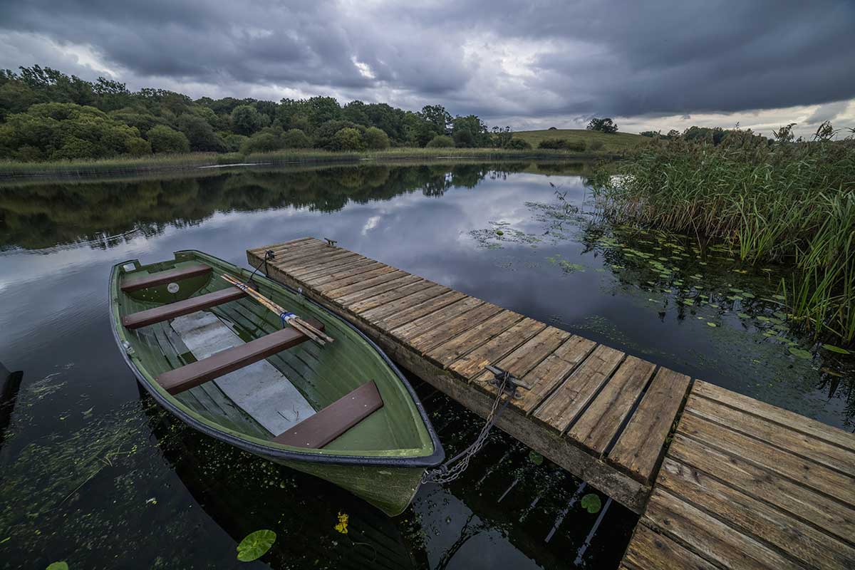 A fishing boat tied up at a wooden jetty on Upper Lough Erne in Fermanagh, Northern Ireland.
