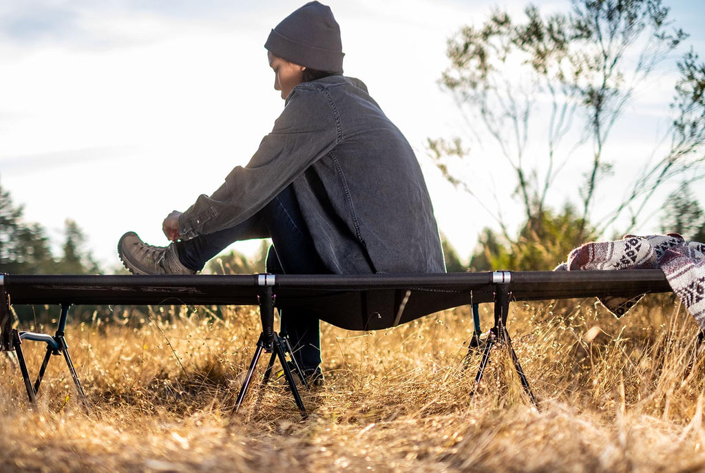 Woman sitting on a Helinox camping cot