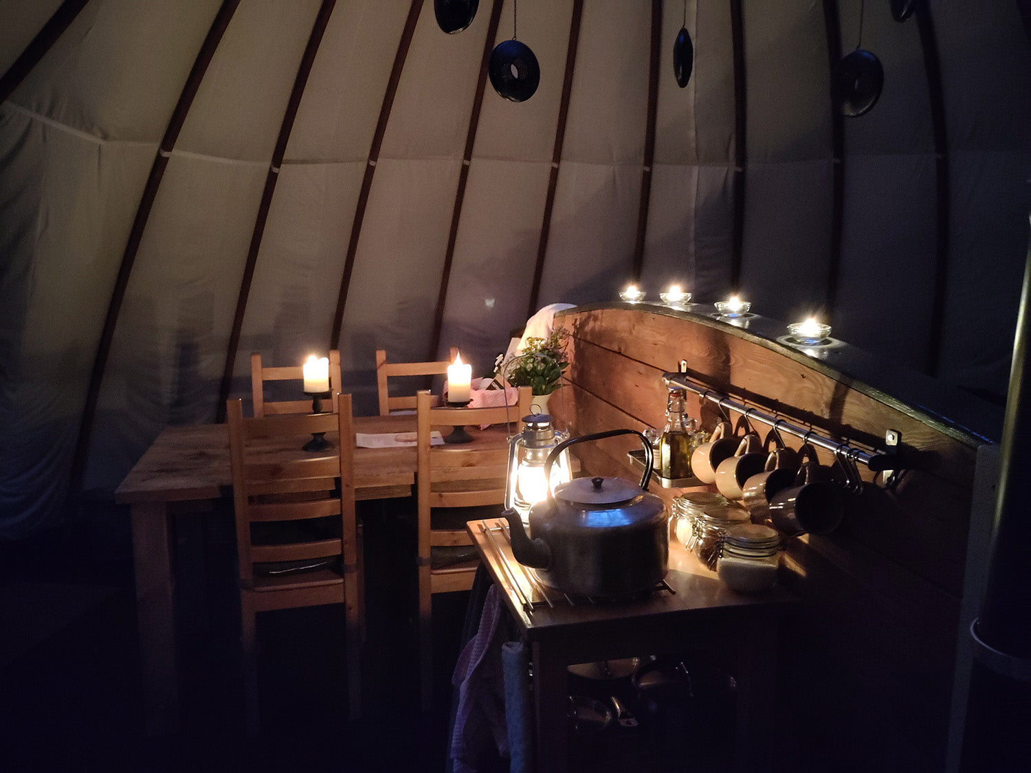 The warm, soft and natural lighting inside an alachigh glamping tent at Penhein