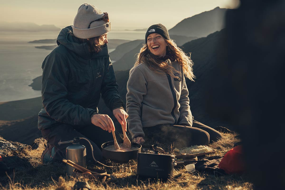 A couple cooking outdoors camping