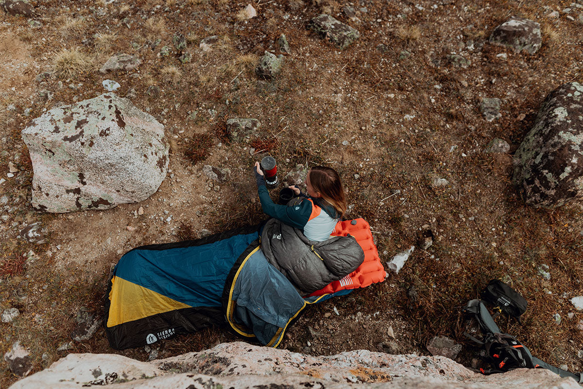 Woman camping using a Sierra Designs sleeping bag